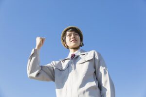 ガッツポーズの男性・作業着・空